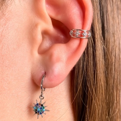 Brincos em prata com pedras coloridas numa orelha