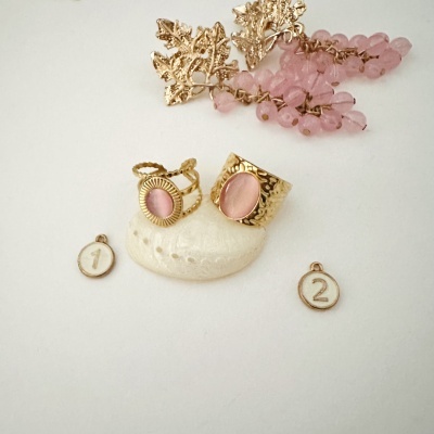 Anéis dourados com pedras rosas e ornamentos com contas rosas