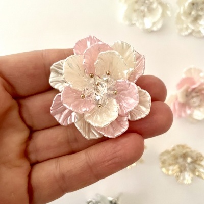 Flor decorativa rosa e branca com pedras no centro