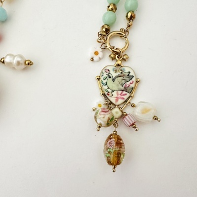 Colar com pendente em forma de coração com desenho de pombo e flores