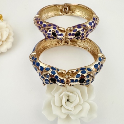 Pulseira dourada com cabeças de pantera azul