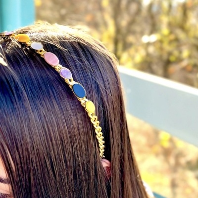 Aro dourado com pedras coloridas em cabelo castanho