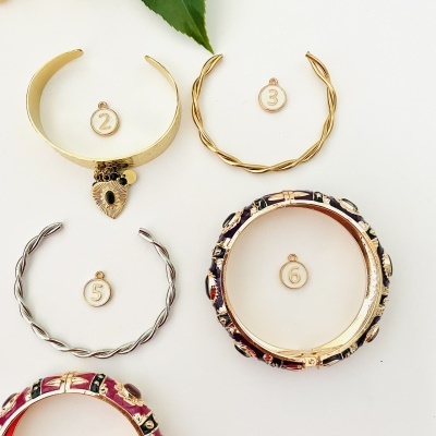 Cinco braceletes numerados em fundo branco com folhas verdes ao topo