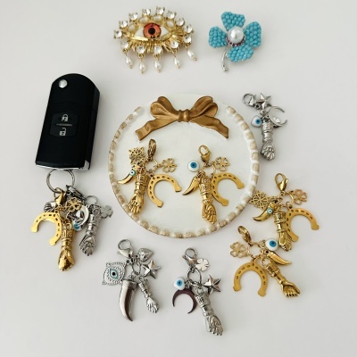 Porta-chaves metalizados com pendentes sorte em fundo branco e prato decorativo