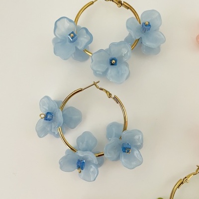Brincos de argola dourada com flores azuis translúcidas