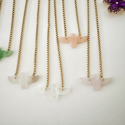 Colares com correntes douradas e pendentes em aves de pedra clara.