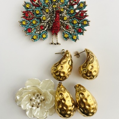 Broche pavão colorido, brincos dourados texturizados e broche flor branca com pérolas