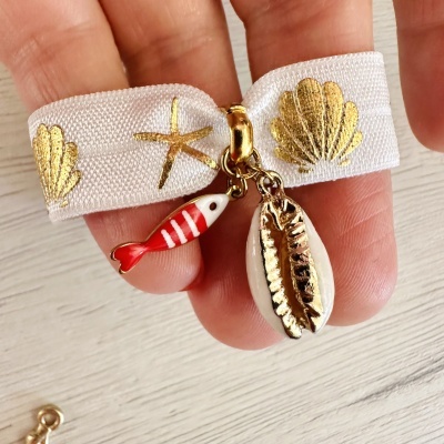 Pulseira branca com motivos marítimos dourados e penduricalhos coloridos