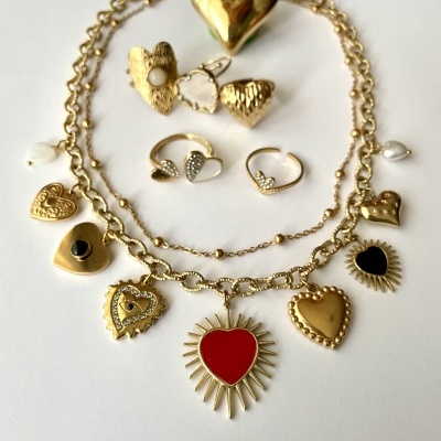 Conjunto de joias douradas com corações e detalhes coloridos