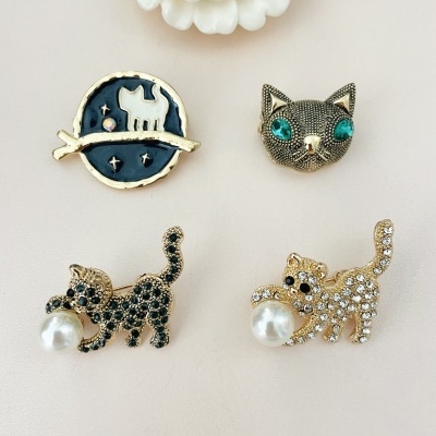 Quatro pins decorativos em forma de gatos com detalhes em pérolas e pedras brilhantes