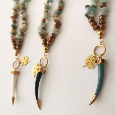 Três colares com contas azuis e castanho e pendentes em forma de dente e folha