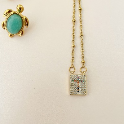 Colar dourado com pendente retangular colorido e broche tartaruga verde.