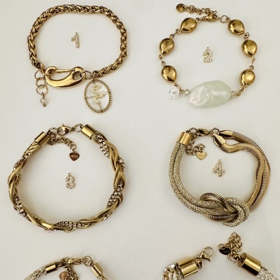 Seis pulseiras douradas numeradas com designs variados sobre fundo branco