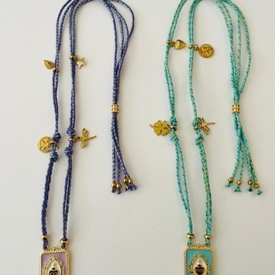 Dois colares com fios azuis e verdes trançados e pendentes metálicos dourados com coração