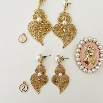 Brincos dourados em filigrana com pérolas e broche rosa com figura feminina e pérolas