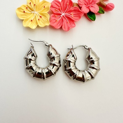 Brincos argola de metal prateado com design ondulado com flores decorativas amarelas e cor-de-rosa