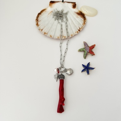 Colar com pendente de coral vermelho e pingentes de conchas e estrelas do mar coloridas sobre concha natural