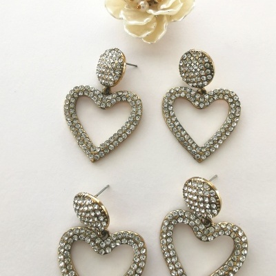 Par de brincos coração dourados com cristais e flor branca decorativa