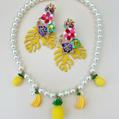 Colar de pérolas com pendentes de frutas amarelas e brinco colorido
