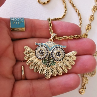 Colar dourado com pendente de coruja com pedras coloridas e corrente torcidada