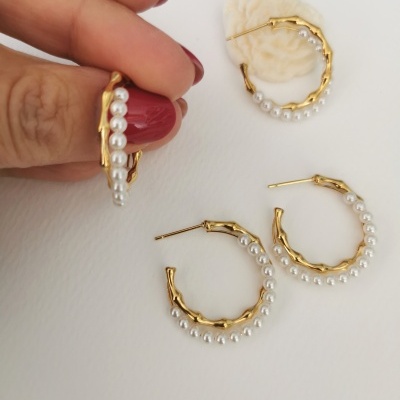 Brincos de argola dourados com pérolas em fundo branco