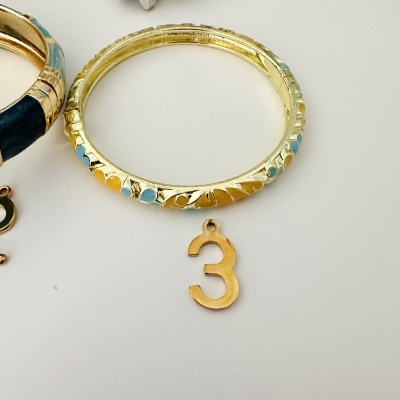 Bracelete dourado com detalhes coloridos e pendente número 3 em dourado