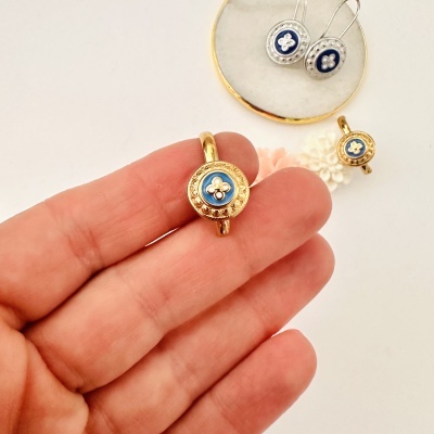 Anel e brincos redondos em metal dourado e prateado com detalhe azul e flores brancas