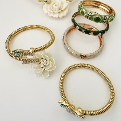 Braceletes dourados com flores e braceletes esmaltados com padrões florais coloridos