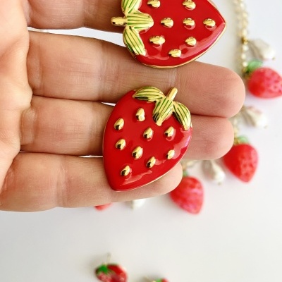 Brincos de morango vermelho com detalhes dourados e verdes