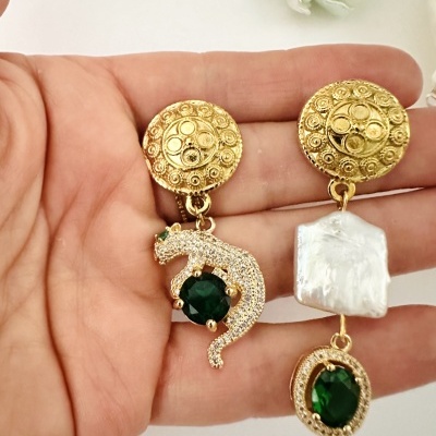 Brincos dourados com pedras verdes e detalhe em pérola e forma de pantera.