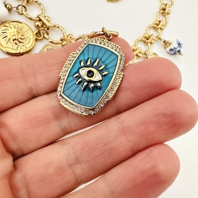 Colar dourado com pendente azul e símbolo de olho