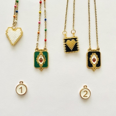 Colares com pendentes em contas coloridas e douradas em fundo branco com etiquetas numeradas.