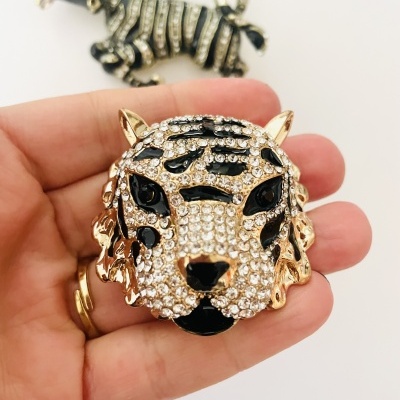 Broche cabeça de tigre com pedras e esmalte preto com broche zebra ao fundo