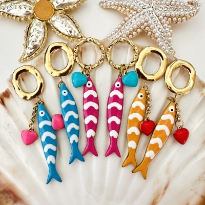 Brincos com peixes coloridos pendurados em concha com decoração dourada e pérolas