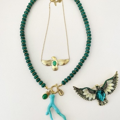 Conjunto de joias com colar, pendente e broche em tons dourado, verde e azul