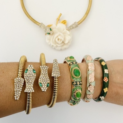 Colares e pulseiras com pedras verdes, brilhantes e padrões florais em fundo branco