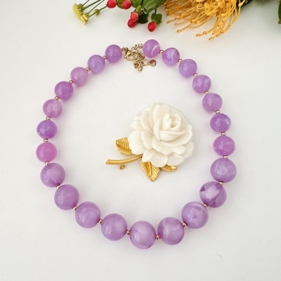 Colar com contas lilases e flor branca decorativa