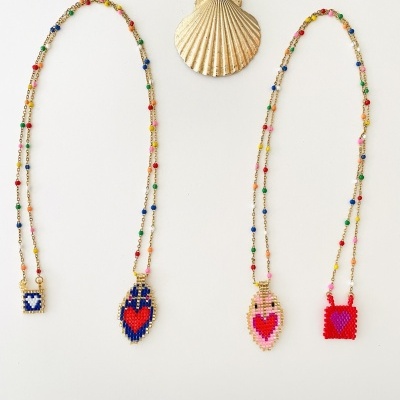 Dois colares coloridos com pendentes de contas e uma concha decorativa ao centro