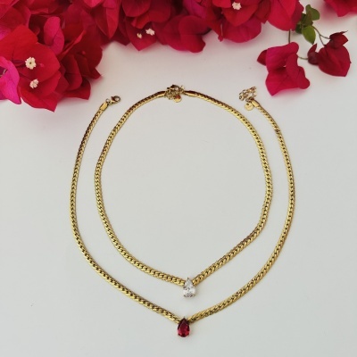 Colares dourados com pedras em forma de gota e flores vermelhas