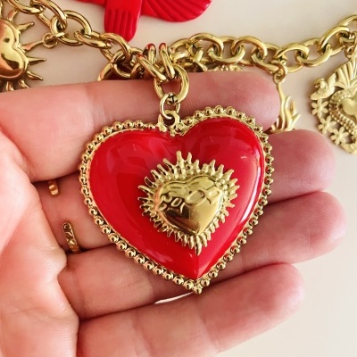 Colar com pingente coração vermelho e detalhes dourados em mão