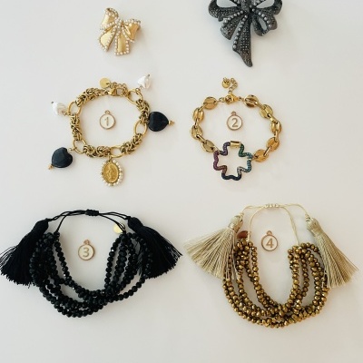 Conjuntos de pulseiras e brincos com diferentes cores e materiais sobre fundo branco