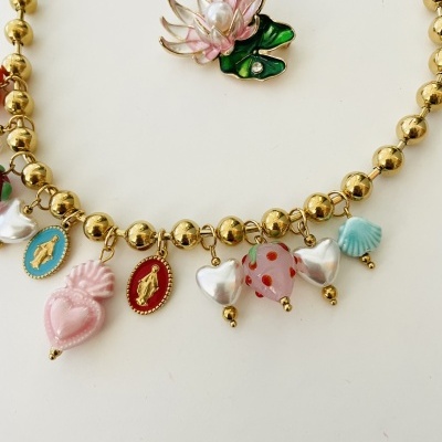 Colar dourado com vários pendentes coloridos de corações, medalhas e concha