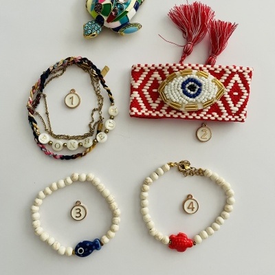 quatro pulseiras numeradas e tartaruga colorida sobre fundo branco