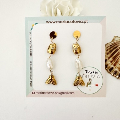 Brincos pendentes dourados e brancos em cartão com texto e ícone de pássaro