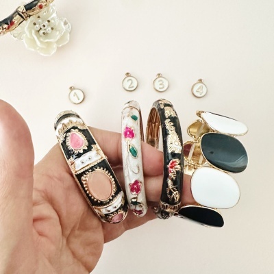 Quatro pulseiras coloridas com detalhes dourados e pedras falsas