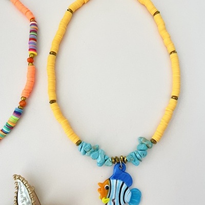 Colar amarelo com pendente de peixe azul colorido e pedras azuis