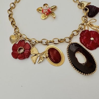 Colar dourado com pingentes coloridos em flores, laço e pedras