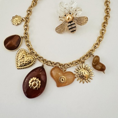 Colar dourado com pendentes em formas variadas e broche de abelha