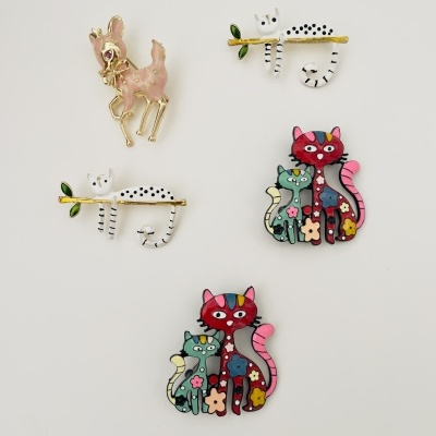 Cinco broches decorativos com desenhos de gatos e veado em fundo branco