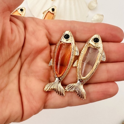 Brincos em forma de peixe com bordas douradas e resina colorida na mão